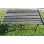 A contemporary but weathered garden table of rectangular form with slatted top raised on