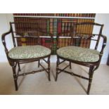 A pair of Regency beechwood elbow chairs with open framework and cane panelled seats, with