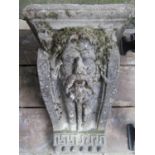 A weathered composition stone corbel/water feature with well defined face mask, Greek key and floral
