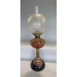 A brass and copper Corinthian column oil lamp, with stepped circular black marble plateau and etched