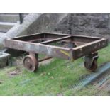 A low industrial fabricated steel framed platform trolley frame with four cast iron wheels, 112 cm x
