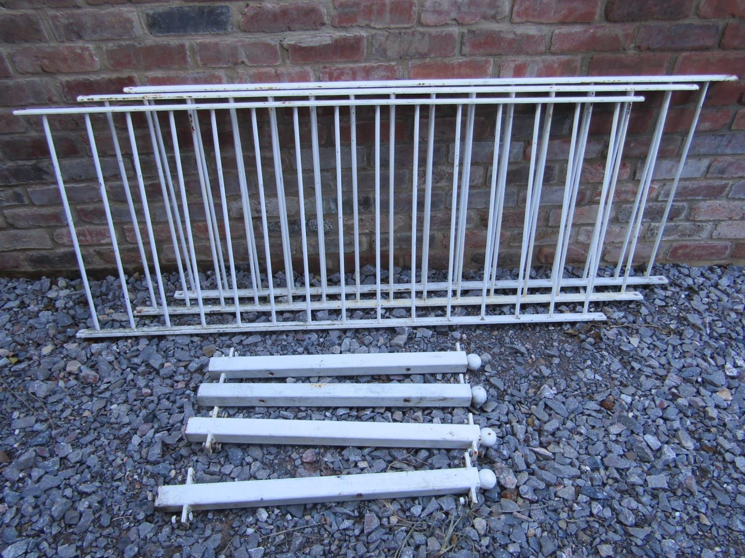 Three sections of cast iron railing with simple vertical solid tubular bars and 4 square posts