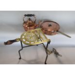 Brass pierced trivet on a wrought iron base with turned wooden handle, with further lidded copper