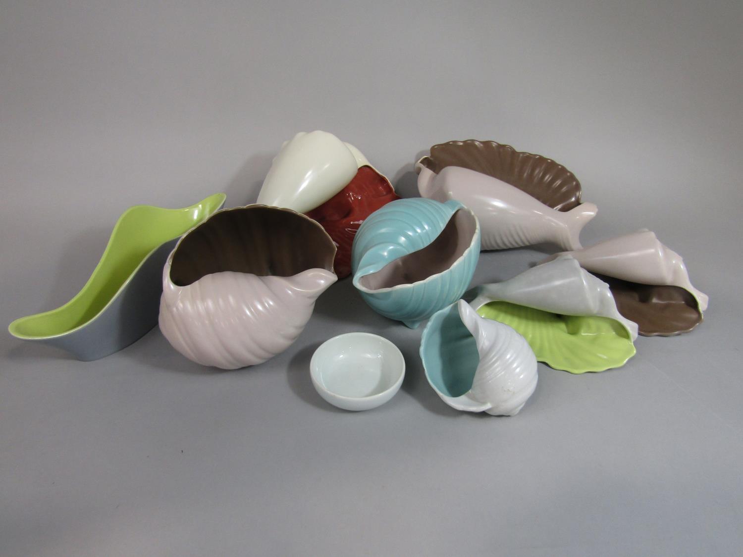 A collection of Poole Pottery vases in the form of shells with various glazed finishes, together