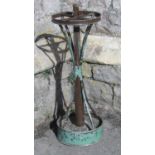 A vintage circular four divisional painted metal umbrella stand with central tubular column and oval
