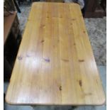 A Victorian style stripped pine kitchen table of rectangular form with rounded corners raised on
