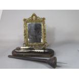 A cast metal easel mirror with inset porcelain panel of a romantic scene, 38cm high, together with a