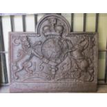 A heavy cast iron fire back of rectangular stepped arched form with raised armorial relief and dated