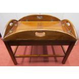 A reproduction butlers tray and stand, the tray with quarter panelled base and drop sides, raised on