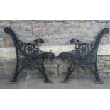 A pair of reproduction cast iron bench ends with decorative pierced foliate detail