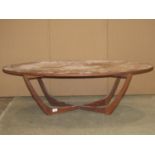 A low mid 20th century teak occasional table of oval form, raised on tapered and moulded X framed
