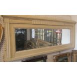 A narrow rectangular wall mirror with distressed bevelled edge plate within a moulded oak frame with
