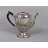 A Georgian style half fluted coffee pot with engraved crest of an arm holding a broken arrow,