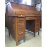 An early 20th century oak kneehole twin pedestal roll top desk (one piece), the S shaped tambour