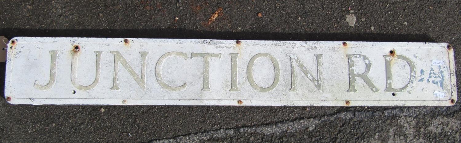 A reclaimed aluminium sign "Junction Road" with painted finish, mounted/screwed onto what appears to