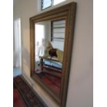 A large contemporary reproduction wall mirror of rectangular form with stepped and moulded gilt
