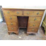 A Georgian mahogany kneehole dressing table fitted with an arrangement of eight drawers and recessed