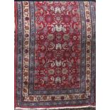 Full pile Persian hand woven city rug, with scrolled bright foliage upon a red ground, 210 x 125cm
