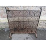 An iron work fire screen/guard of rectangular form with wire mesh backed tight scroll repeating