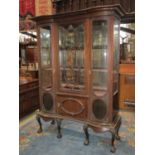 An Edwardian walnut display cabinet freestanding and enclosed by a pair of slender bow fronted