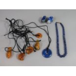 Five cord necklaces with amber pendants, plus a lapis lazuli example, a further pair of carved lapis