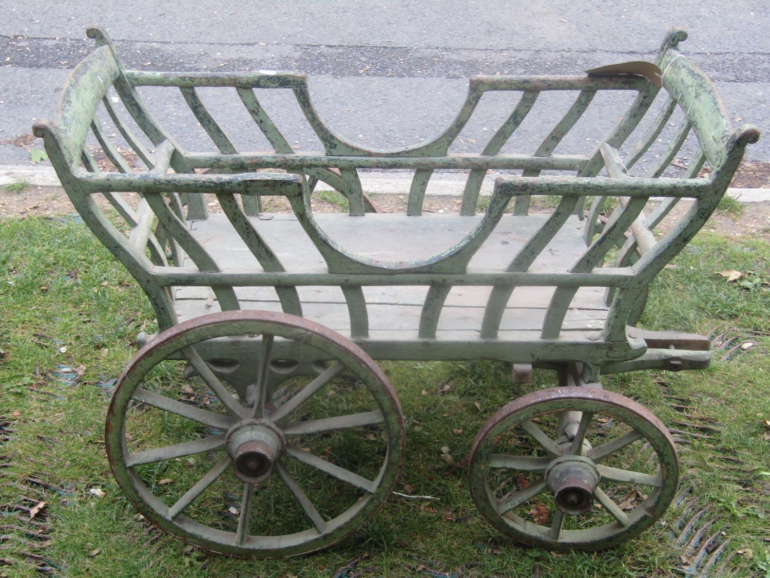 A small old vintage agricultural type hand/dog cart with shaped splats, spoke wheels, iron rims