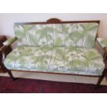 A small inlaid Edwardian mahogany parlour room sofa with marquetry panels, raised on square taper