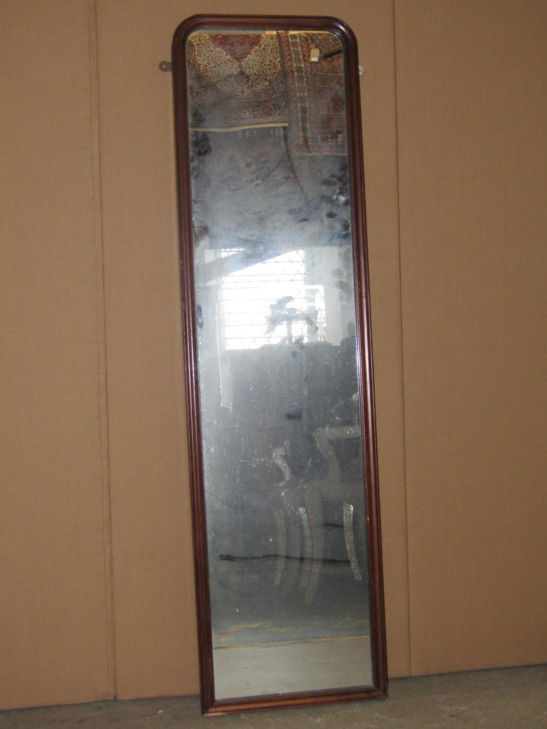 A Georgian style wall mounted dressing mirror of rectangular form with moulded frame and rounded top