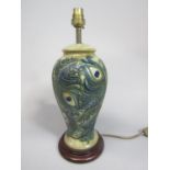 A Moorcroft ceramic lamp base, with painted and moulded peacock feather design in the art nouveau