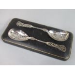 Good quality pair of fancy silver serving spoons with relief floral bowls and pierced scrolled