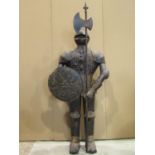 A floorstanding decorative scale replica of a suit of armour (knight) clutching a circular shield