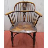 A Georgian Windsor elbow chair in elm and ash, turned supports, crinoline stretcher and shaped and