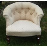 A low Victorian tub chair with lattice patterned upholstered seat and button back raised on turned