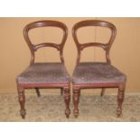 A set of four Victorian mahogany balloon back dining chairs with carved splats, upholstered seats