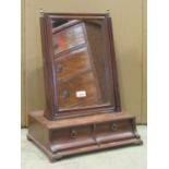 A Georgian mahogany toilet mirror of rectangular form with moulded frame and box base fitted with