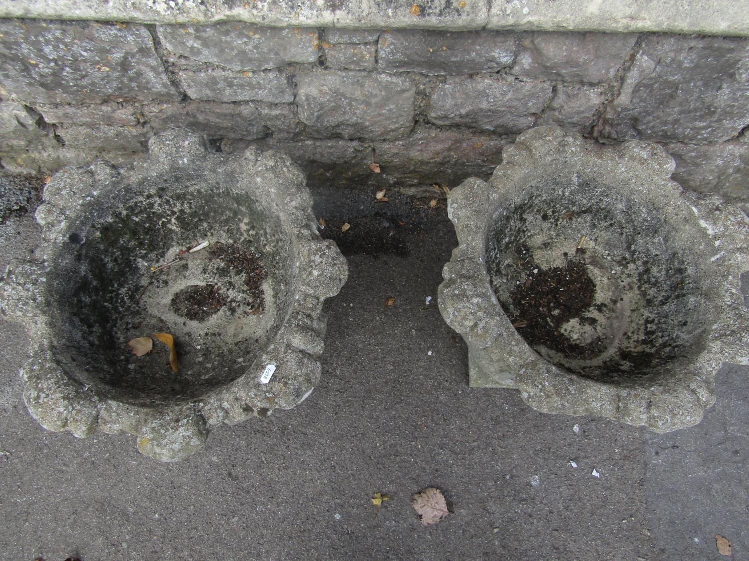 A pair of weathered composition stone garden urns with cabbage leaf bowls and square platform bases, - Image 3 of 4