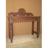 A carved oak hall table with mask, trailing fruit, gothic tracery and acanthus detail, 104 cm wide