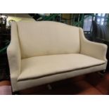 An Edwardian period cottage sofa, upholstered in calico, raised on square tapered mahogany