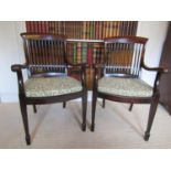 A pair of 19th century mahogany elbow chairs, with scrolled arms, stick backs and cane panelled