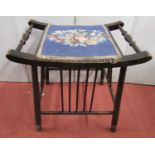 An arts and craft stool on turned supports and rails, the dished top enclosing a hand worked