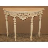 A console table with shallow break front, painted finish, scrolled acanthus frieze, tapered supports