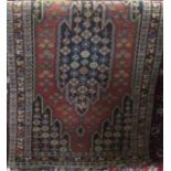 A Persian rug with central blue floral medallion upon a burnt orange ground, 150 x 95cm