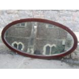 An Edwardian mahogany framed wall mirror of oval form with bevelled edge plate 136 cm x 68 cm