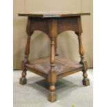 An Arts & Crafts style oak two tier occasional table with copper clad top raised on splayed turned