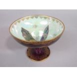 A Wedgwood lustre bowl raised on a circular foot, with dark red speckled glaze to the exterior in