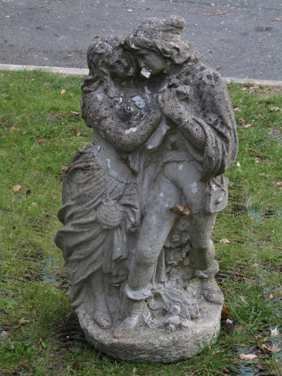 A weathered cast composition stone garden figure group in the form of a romantic couple, 70 cm high,