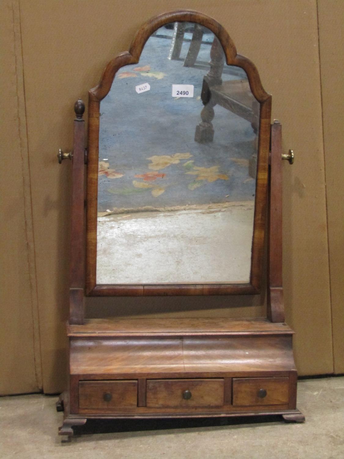 An antique Queen Anne style walnut veneered toilet mirror with moulded arched frame over an ogee box