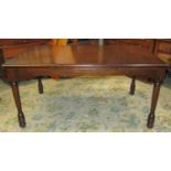 A dark stained oak veneered draw leaf dining table of rectangular form raised on turned supports