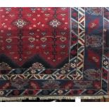A large full pile Afghan country house carpet with various medallion decoration upon a red ground,