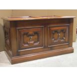 A good quality reproduction oak chest in the Jacobean style with distressed finish, twin panelled